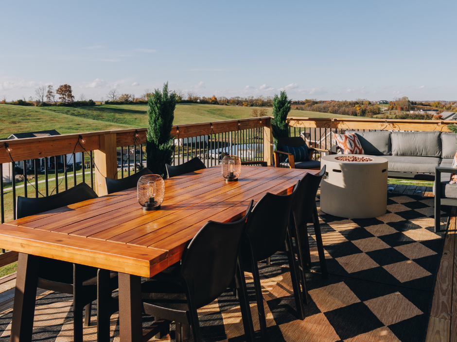 Outdoor modern deck with wooden table, chairs, and a view of a Kentucky field.